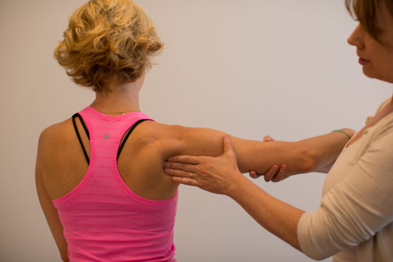 Therapist performs a shoulder treatment.