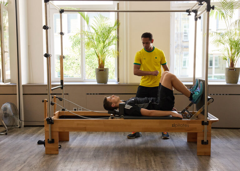 Exercise on the Pilates Reformer Cadillac under expert guidance
