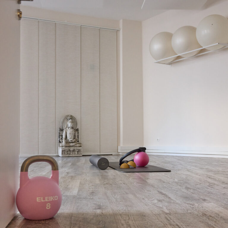 Übungsraum mit Kettlebell, Yogamatte, Faszienrolle und Buddha-Statue