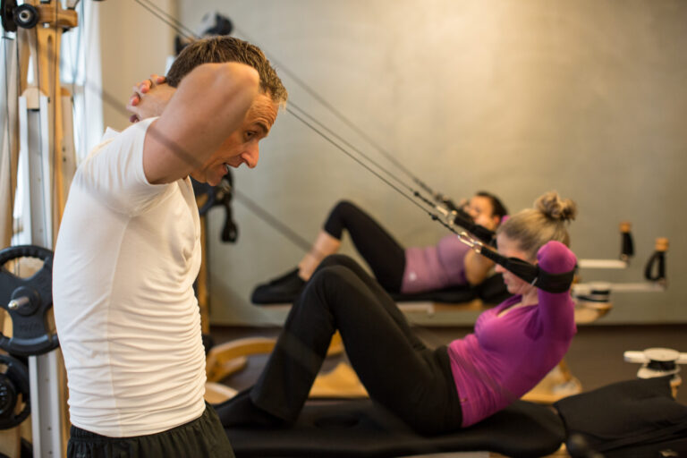 Participants perform a roll-up on the Gyrotonic tower.